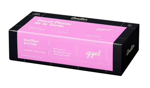 A black and pink coffee box of Decaf Placer De La Tarde featuring pomegranate and cherry blend in minimalist design
