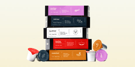 Stacked decaf coffee boxes in vibrant packaging with matching capsules highlighting smooth, caffeine-free blends