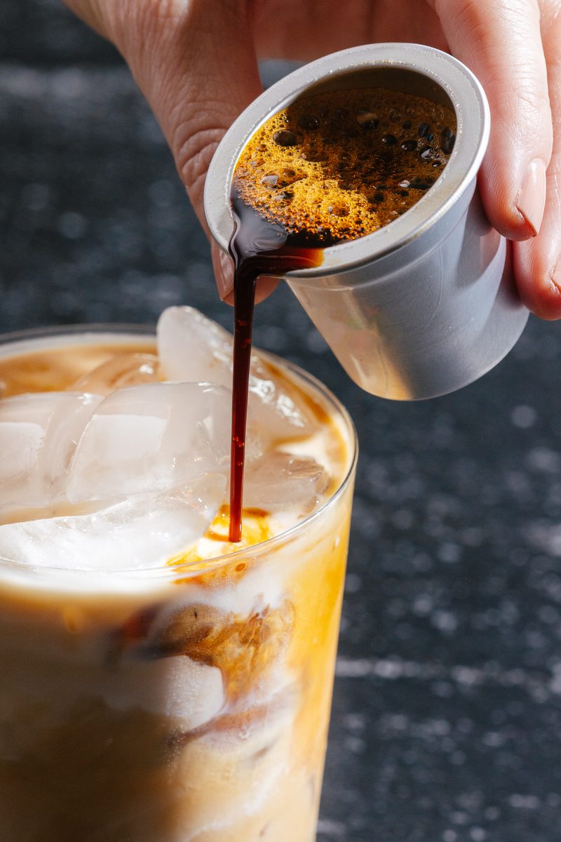 Pouring concentrated coffee over ice and milk