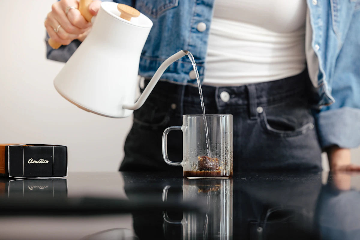 Hot water poured over a Cometeer capsule in a glass mug