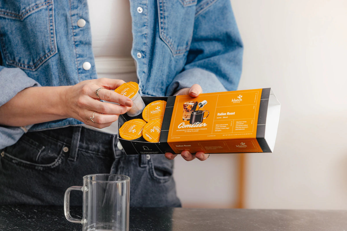 Person selecting a Cometeer coffee capsule from a sleeve